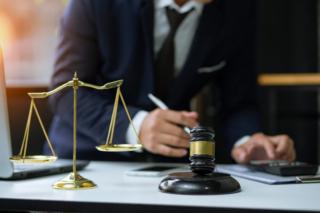 Lawyer working at desk with gavel and justice scales in office.