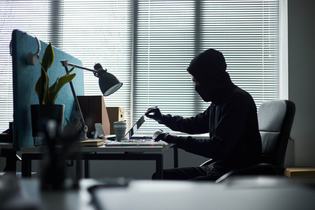 A person in Pennsylvania illegally accessing company data on a laptop, illustrating a common whistleblower mistake that can lead to claims of misconduct.