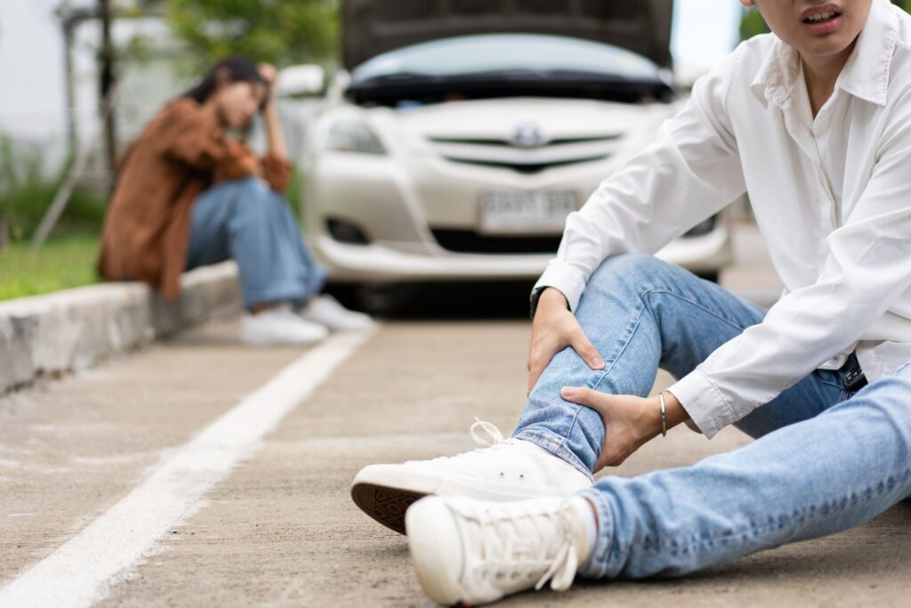 Injured victim holding their leg after a crash, illustrating the process of determining fault in Pennsylvania car accident claims.