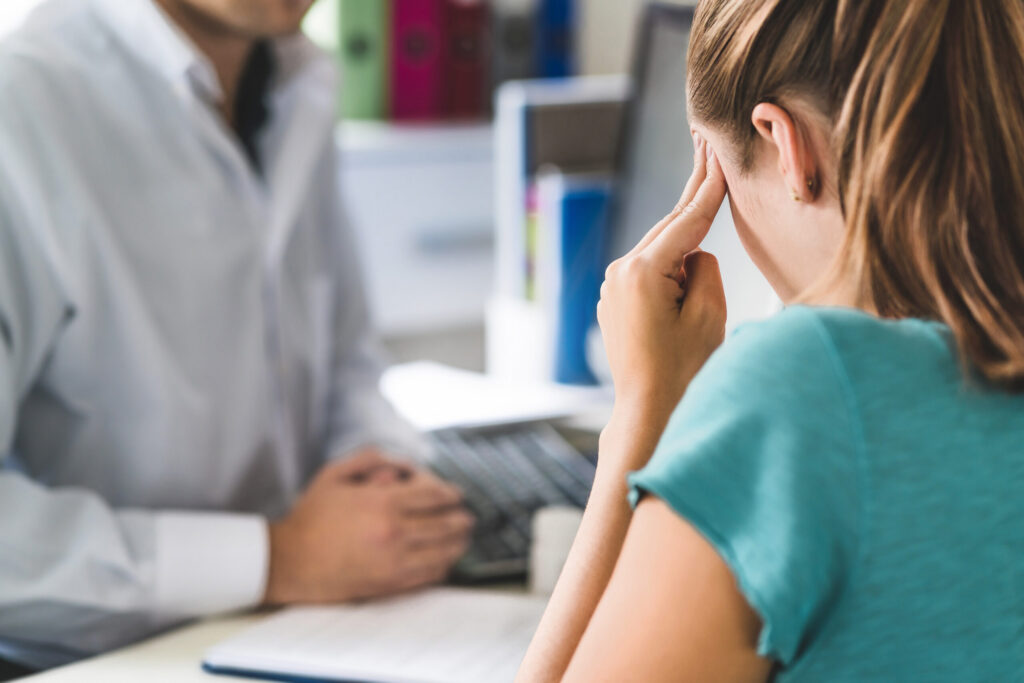 A person in Pennsylvania suffering from a traumatic brain injury discussing symptoms with a doctor to determine settlement value.