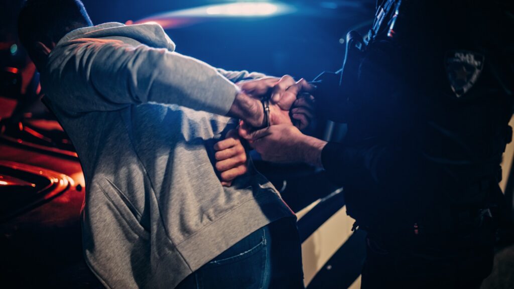 Police officer using force to arrest an individual against a vehicle in Pennsylvania, relevant to claims of excessive force.