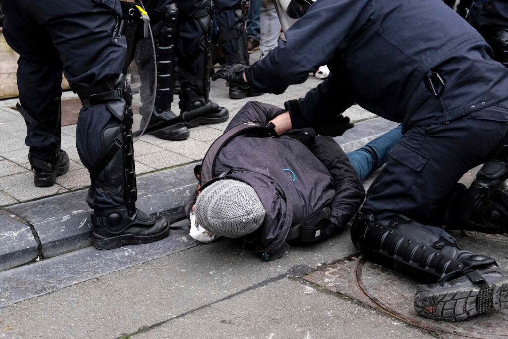 A person pinned to the ground by several officers, illustrating a potential case of excessive police force in Pennsylvania.