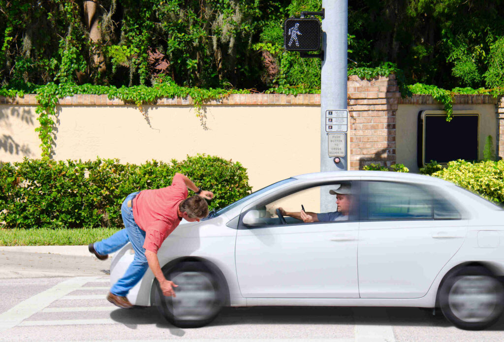 A pedestrian entering a Center City Philadelphia crosswalk with the walk signal, where driver inattention often leads to serious collisions.